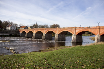 Fototapeta na wymiar old Brick bridge across the River Venta in the city of Kuldiga Latvia