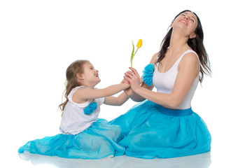 Mom and daughter with a flower of tulip.