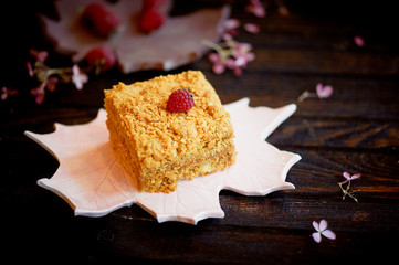 A piece of sweet honey cake on a plate in the form of a maple leaf. Cakes