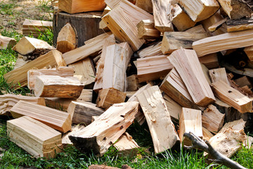 A pile of chopped firewood logs ready for the winter. Cut logs fire wood. Hardwood, wood and lumber industry. Heating season, winter season. Renewable resource of energy. Environmental concept.