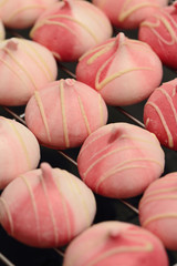 Raspberry and white chocolate meringues on a cooling rack