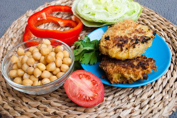 Falafel with tomato, bowl of chickpea and cilantro on gray background. Healthy food, vegetarian cutlets.