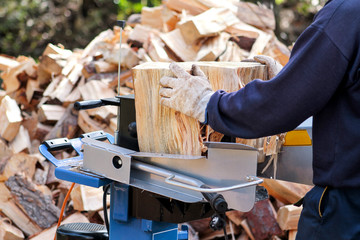Saw cutting wood for winter. A man cutting firewood for the winter using a modern machine lumber saw. Wood industry. Heating season, winter season. Renewable resource of energy. Environmental concept.