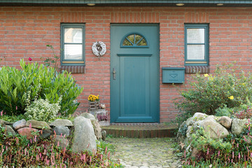 Grüne Haustür eines Hauses mit Briefkasten und Fenstern
