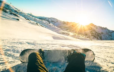Photo sur Plexiglas Sports dhiver Snowboarder assis au coucher du soleil sur un moment de détente dans la station de ski des Alpes françaises - Concept de sport d& 39 hiver avec un gars d& 39 aventure au sommet de la montagne prêt à descendre - Point de vue des jambes avec filtre sarcelle