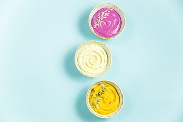Snacks in the form of sauces from carrots, beets and hummus from chickpeas. in bowls on a contrasting blue background