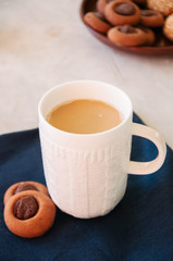 Cup of coffee and thumbprint cookies on a white background.