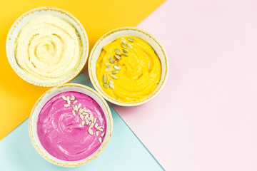 bright appetizers in the form of vegetable sauces and hummus of chickpeas on a combination multicolored background. Copyspace