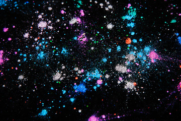 Colorful powdery space star splashes, galaxy concept, top view. Professional abstract pigment cosmetics background and colourants for creative make up