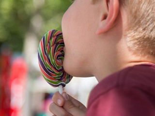 Eight Years Child Licking Colorful Round Lollipop