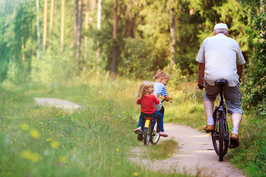active senior with grandkids riding bikes in nature