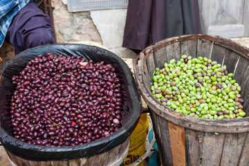 Freshly harvested green and black olives in a wooden basket for sale at Sineu market, Majorca, Spain