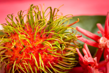 rambutan fruit on wood color pink with flower