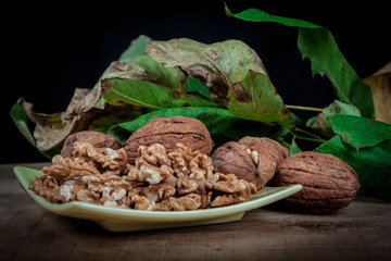 walnuts (Juglans regia) on a black background with leaves from the stoma