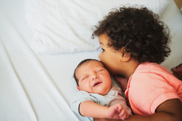 First meeting of adorable african toddler boy and his newborn brother in a prenatal hospital