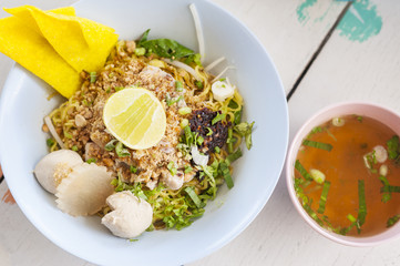 Yellow Noodles dry on white wood table with soup