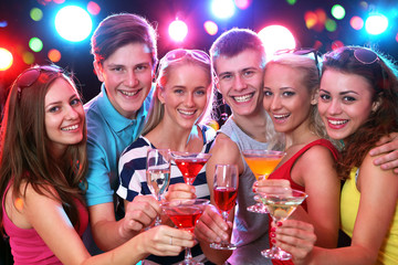 Young friends touching the glasses with each other