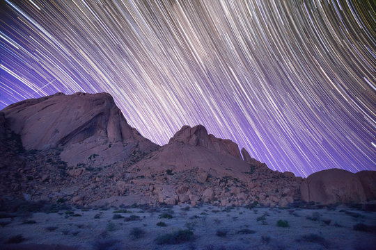 Timelapse of stars in night sky over mountains