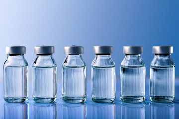 Row of vials on blue table and blue background front view