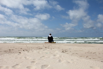 man sits by the sea