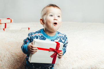 Child standing on a solid background with a gift in hand
