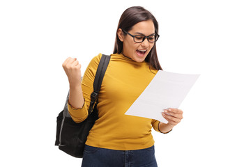 Female teenage student looking at an exam and gesturing happiness