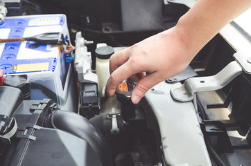 Check the condition of the car engine, repair or maintenance concept. Professional car mechanic fixing a car engine in auto repair workshop service. Selective focus.