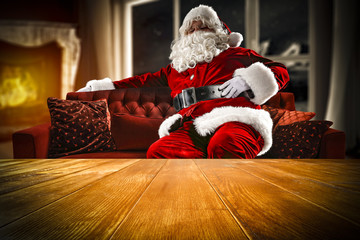 Obraz premium santa claus on sofa and wooden table place 