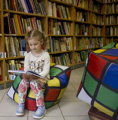 a girl reads a book in the library
