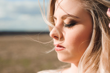 Portrait of beautiful blond woman in a field