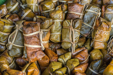 A group of Thai dessert of seasoned steamed sticky rice wrapped in banana leaves.