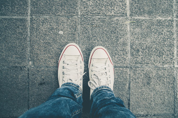 White Sneakers shoes walking on Dirty concrete top view  , Canvas shoes walking on Dirty concrete
