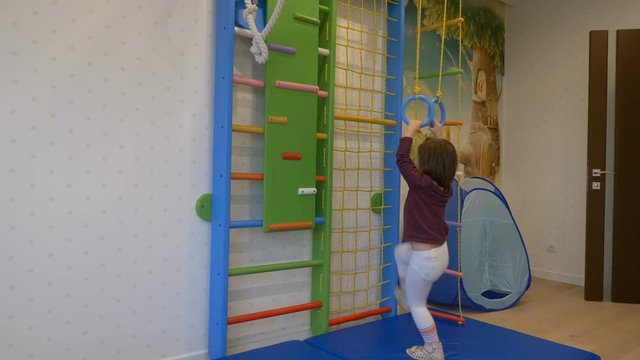 girl playing sports on the wall bars
