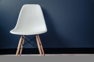 white plastic chair on blue wall