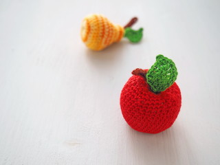 Crochet apple and pear close up. Knitted toys. Selective focus. Copy space for your text.