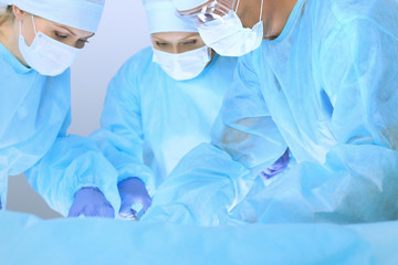 Fototapeta premium Medical team performing operation. Three of surgeons at work are busy of patient. Medicine, veterinary or healthcare and emergency in hospital