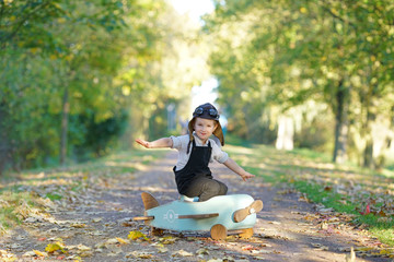 lachendes Kind im Holzflieger, im Herbst