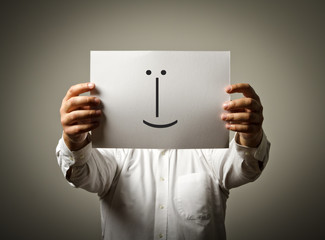 Man is holding white paper with smile. Liar concept.