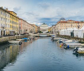 Obraz na płótnie Canvas Trieste, Italy: The Canal is the prized jewel in the centre of Trieste and is lined with beautiful buildings and outdoor cafes which lead up to the amazing sight of Saint Antonio Church