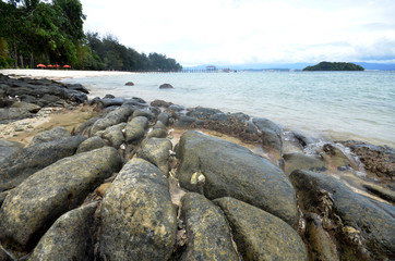 Fototapeta na wymiar Cloudy and rocky beach in Manukan island