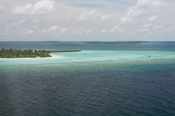 Tropical islands and atolls in Maldives in Indian Ocean from aerial view. Piece of paradise on the Earth. Good choice for vacation. Beautiful top view for wallpaper.