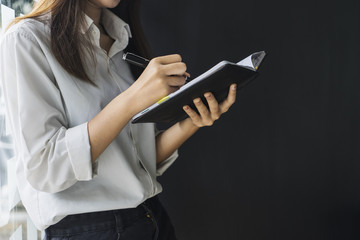 female hands with pen writing on notebook	
