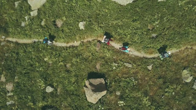 Aerial shooting from flying drone hiking group walking on mountain trail