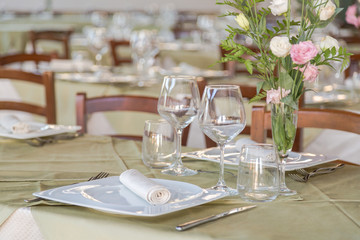 Elegant table set with cutlery, plates and glasses