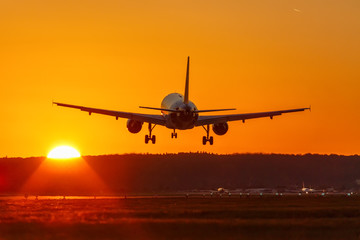 Fototapeta na wymiar Flugzeug landet Flughafen fliegen Sonne Sonnenuntergang Ferien Urlaub Reise reisen