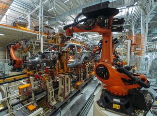 Automobile plant, welding process, modern production of cars, robot equipment, automated production line.
