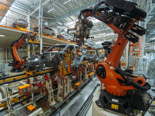 Automobile plant, welding process, modern production of cars, robot equipment, automated production line.
