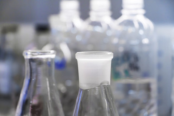 Closeup of chemical glass bottle - concept of chemistry, lab, science, pharmacy and clinical research. Selective focus.