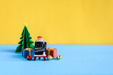 doll and gift boxes on wood desk yellow wall background