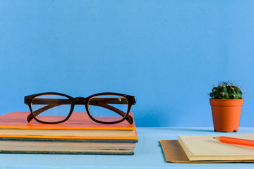 Books Pencil and glasses on a blue wooden table